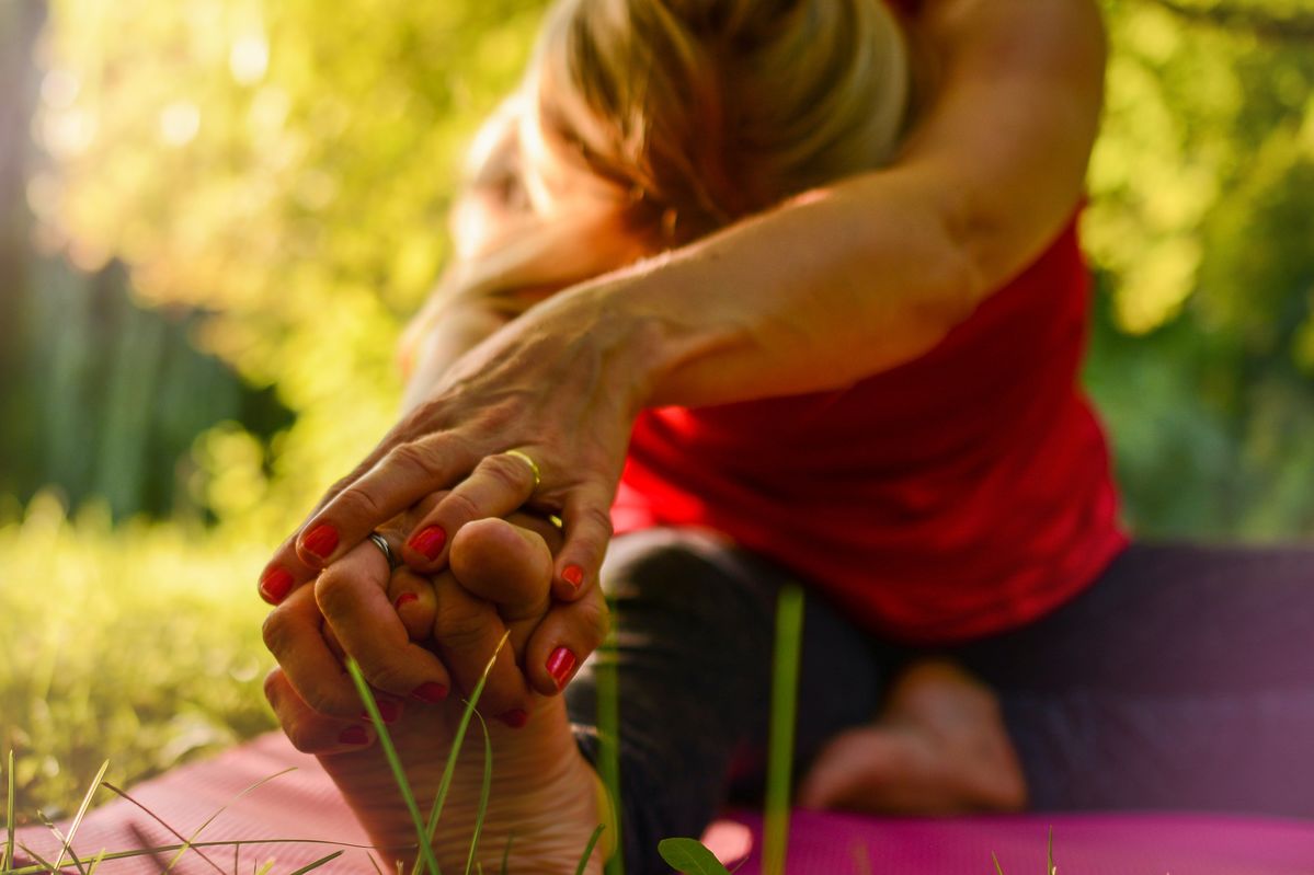 woman doing a yoga stretch outside