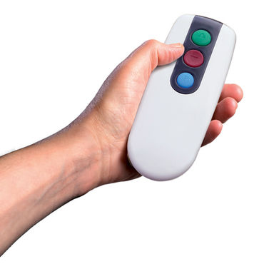 A white remote control with three colored buttons is held in a person's hand against a plain white background.