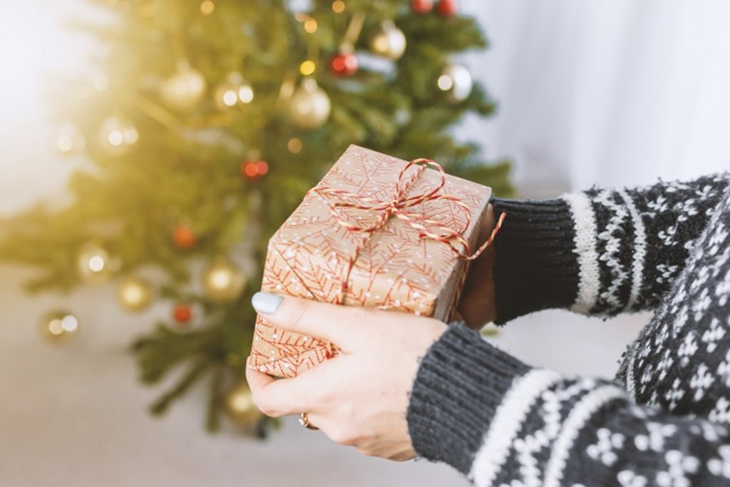 A woman holding a present with her arms outstretched