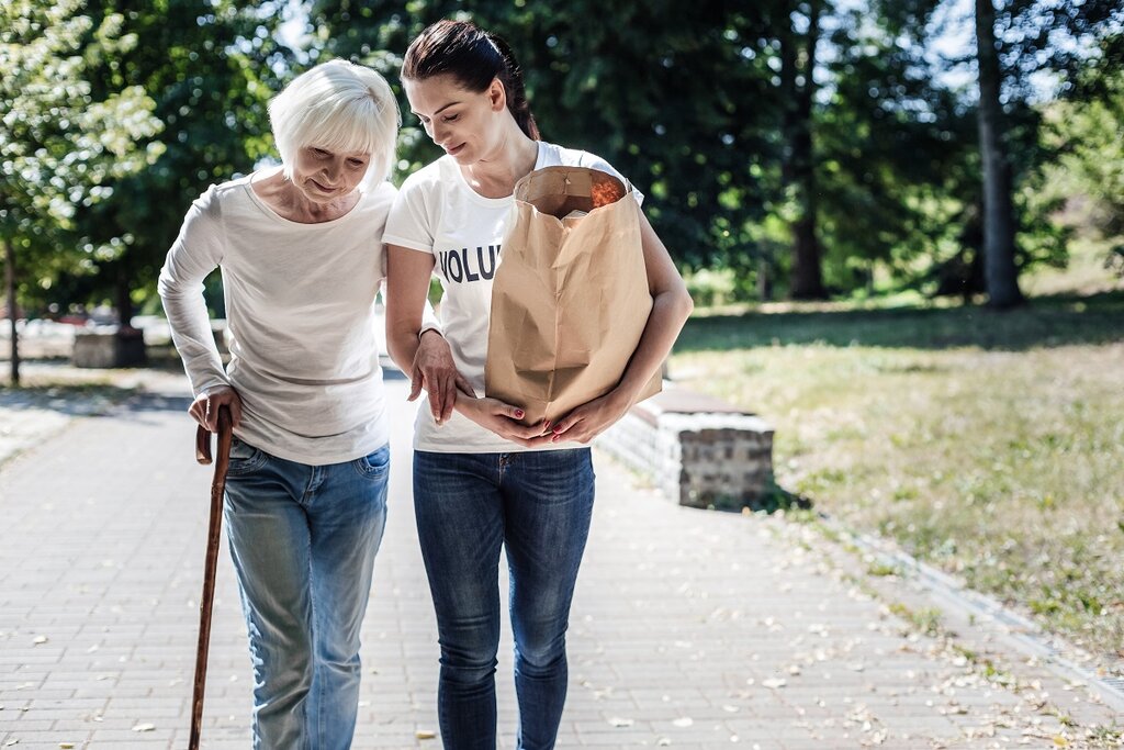 Woman helping older lady with bag