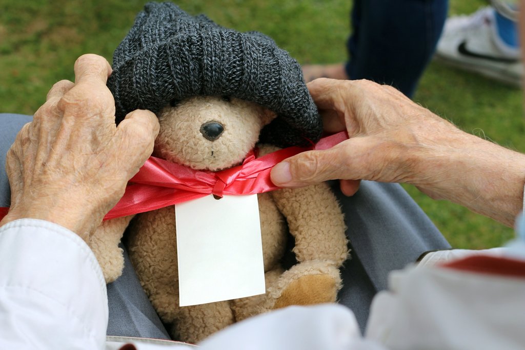 Older person holding a soft toy bear