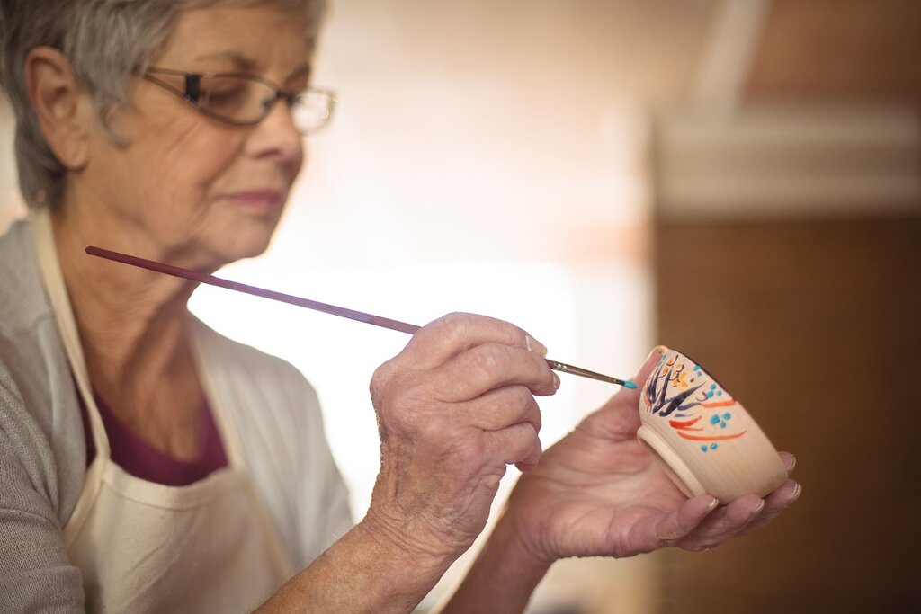 Woman painting a cup