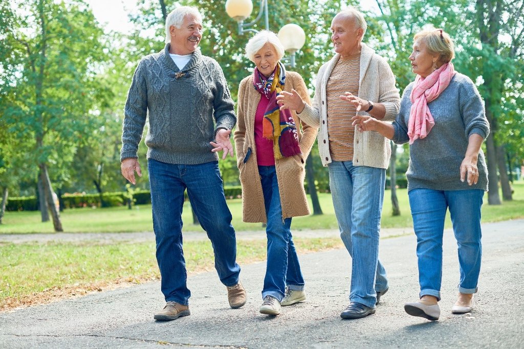 Four older people walking and chatting