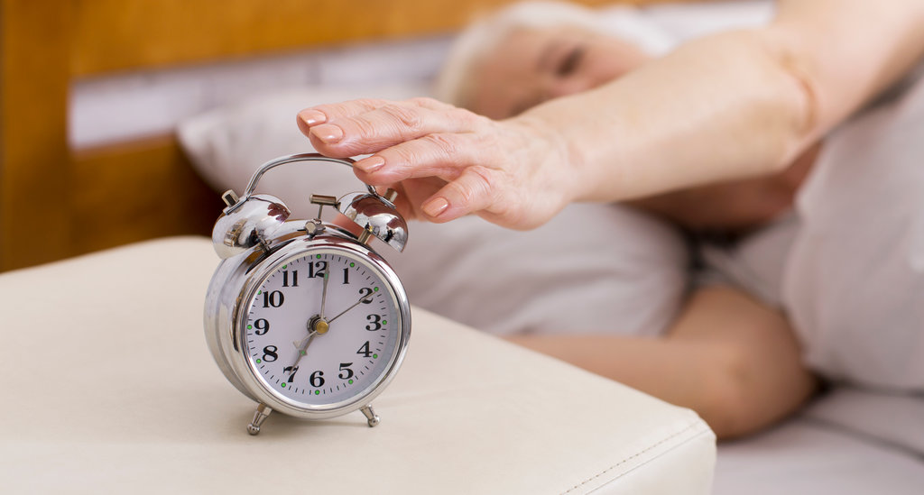 Person turning off alarm clock