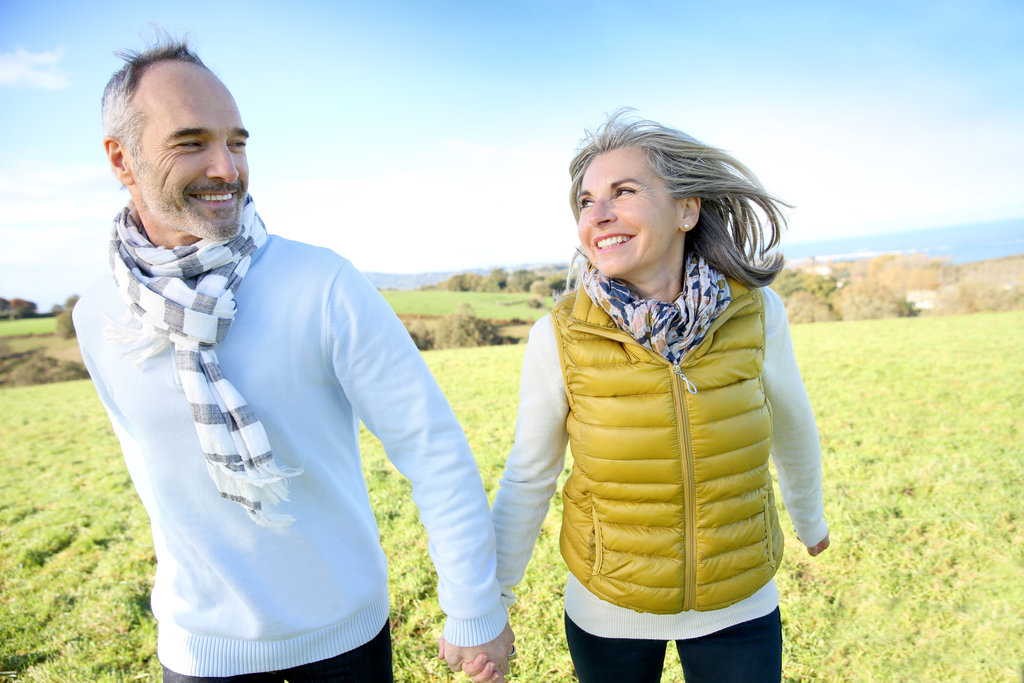 Two old people holding hands and walking