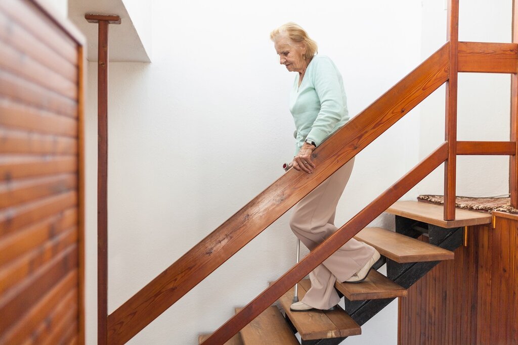 An older lady walking down a staircase