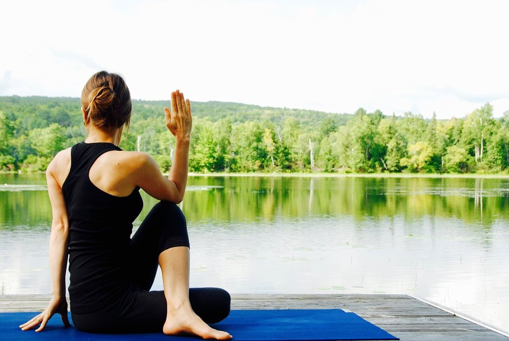 Woman doing yoga next to a lake