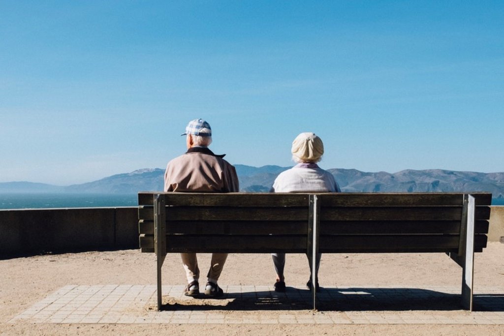 Two older people sitting on a bench