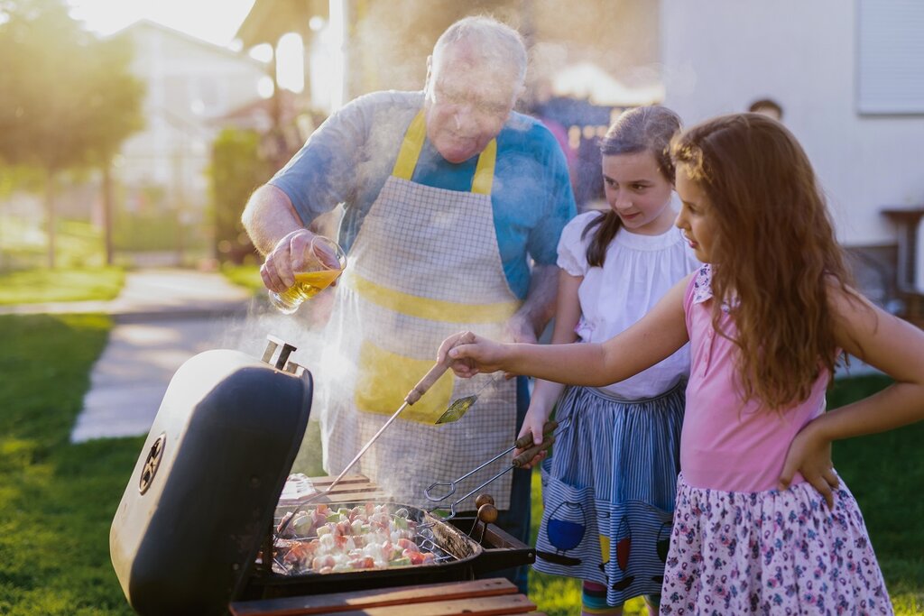 Grandfather cooking BBQ with grandkids