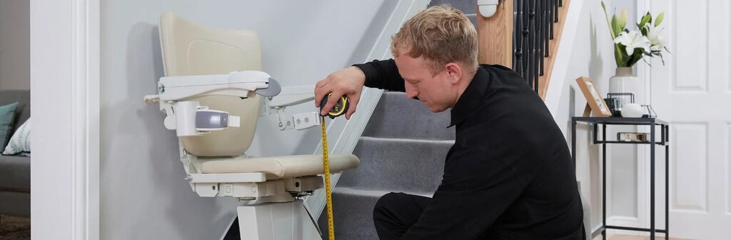 A stairlift engineer measures a new stairlift