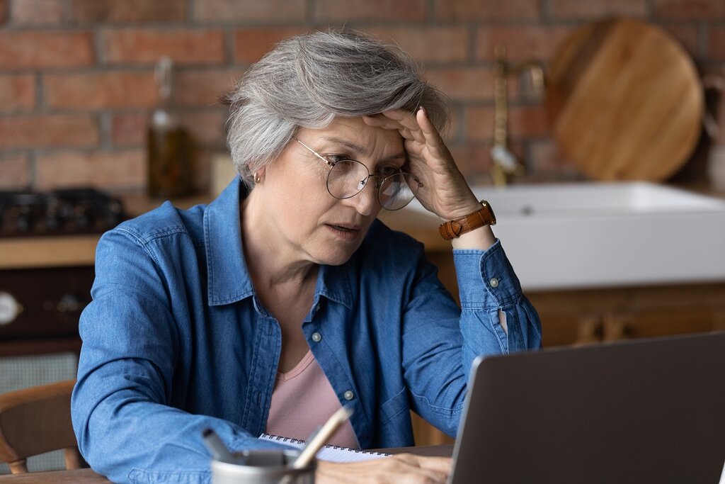 Distressed senior woman on laptop
