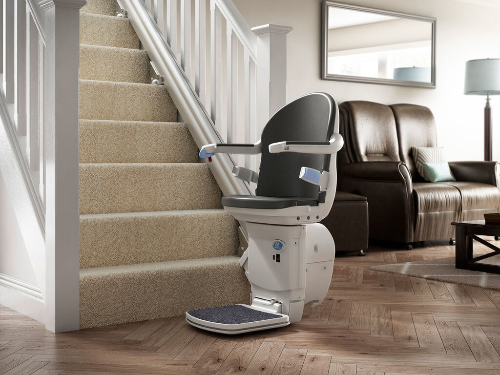 A straight stairlift parked at the bottom of the staircase