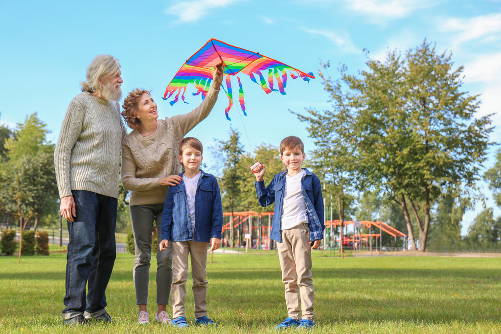 Grandparents flying a kite with their grandchildren