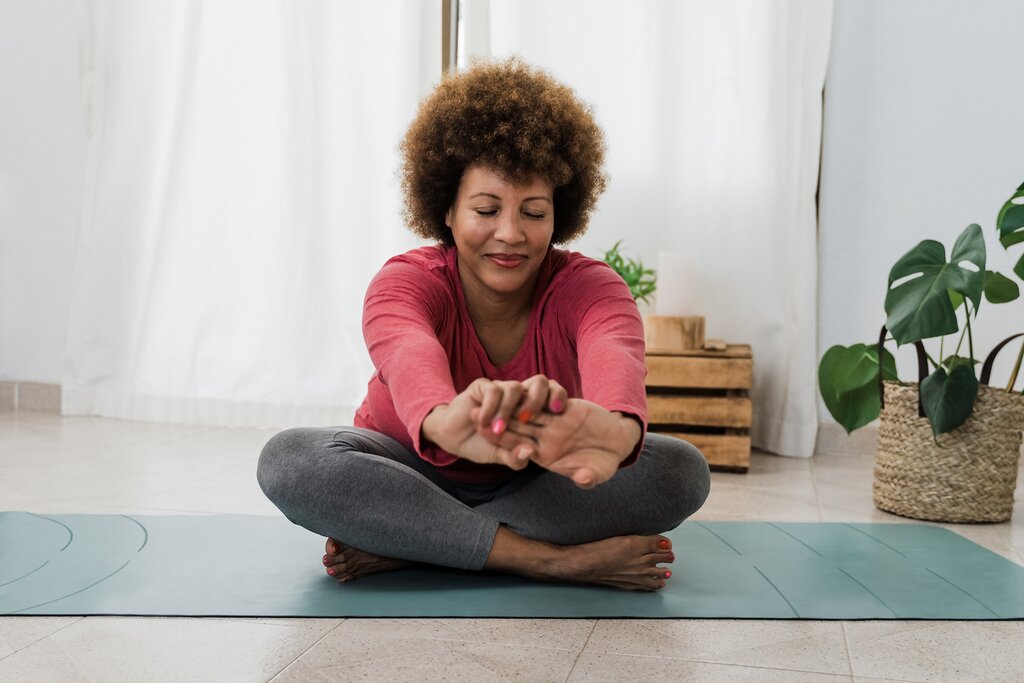 Older women doing morning stretches on yoga mat