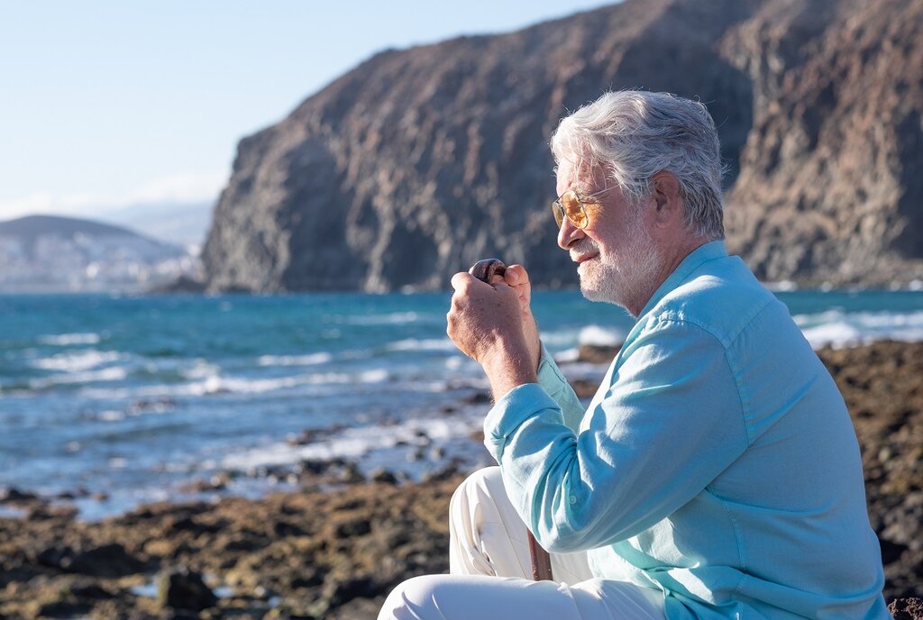 Man on beach with walking stick