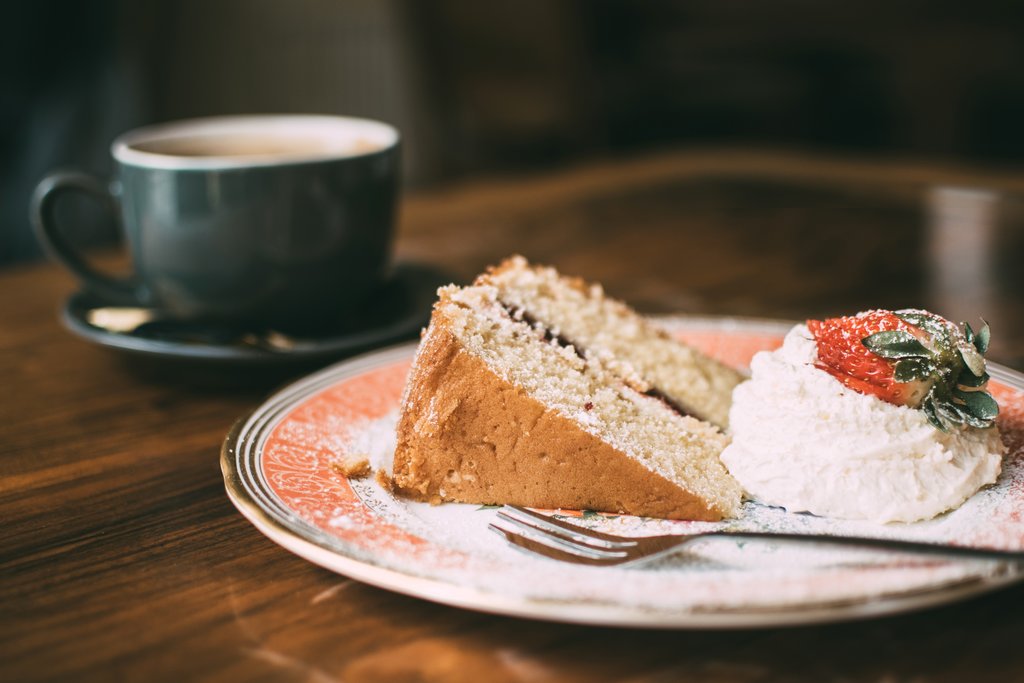 cup and saucer and a slice of cake and cream