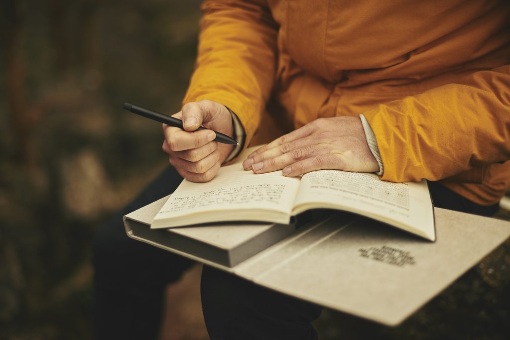 Older person writing in a book