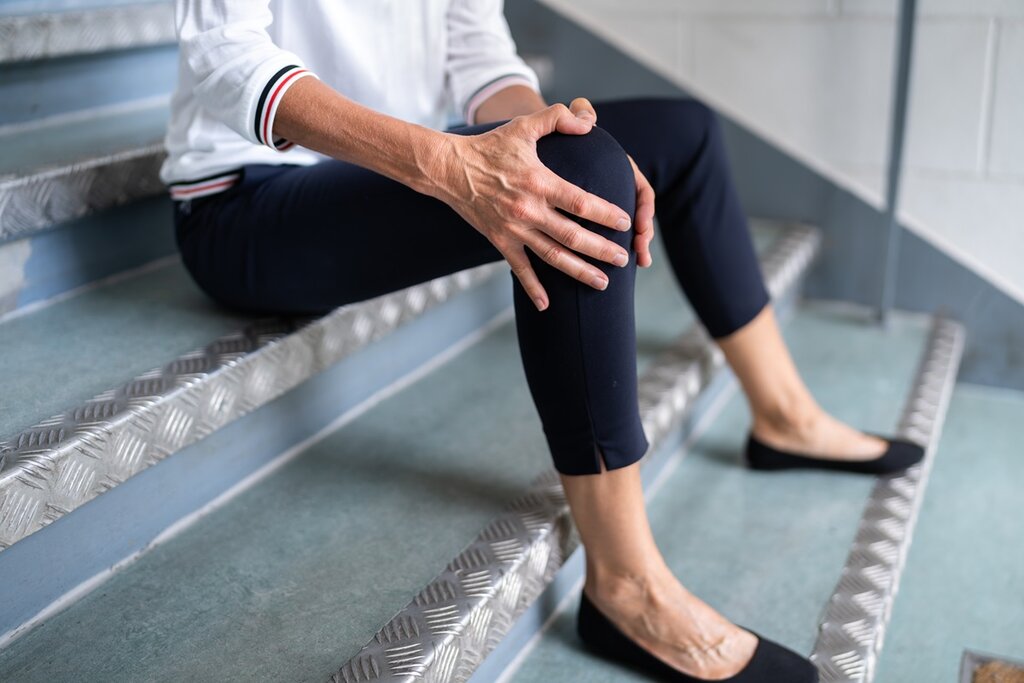 A lady with an injured knee on a staircase