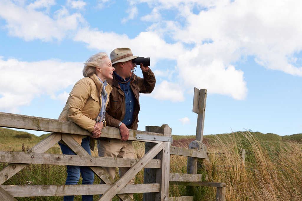 Two older people birdwatching